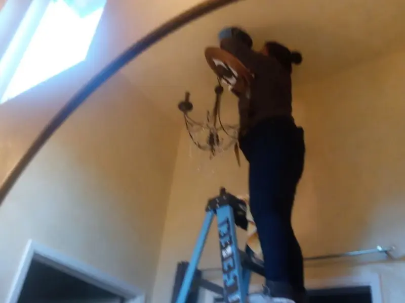 Electrician installing a chandelier in a Columbia residence